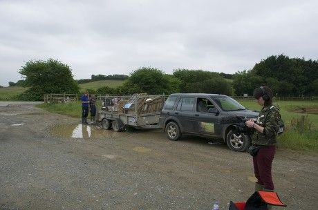 Hannah Sneyd is preparing her camera equipment for filming scenes of the water vole release for the BBC documentary, The Burrowers. In the background is a vehicle and trailer containing equipment for the water vole release.